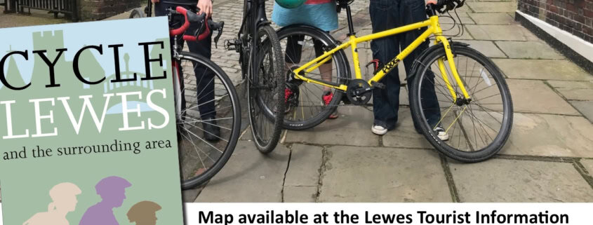 Three people with bicycles look at a map near a historic stone gateway. An inset shows the “Cycle Lewes” map cover and details about cycling resources and information for Lewes.