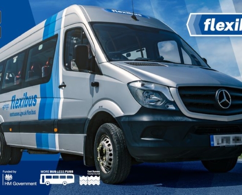 A silver Flexibus minibus is parked on a road under a blue sky. The vehicle features blue stripes and the Flexibus logo. App store icons and partner logos appear in the corners of the image.